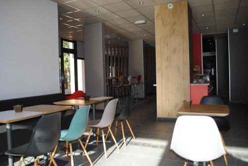 a restaurant with wooden tables and chairs at ibis Hyeres Centre in Hyères