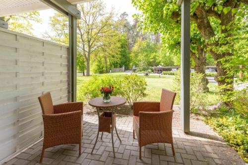 a patio with chairs and a table with a vase of flowers at Seehotel Lindenhof in Lychen