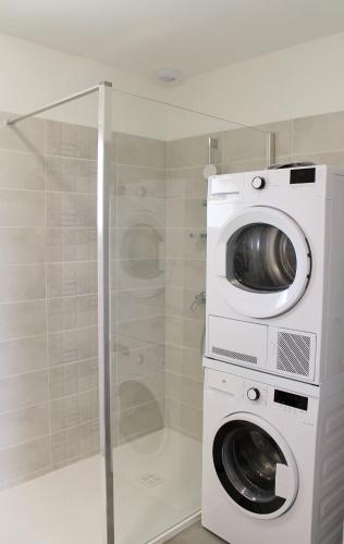 une machine à laver et une machine à laver dans une salle de bain dans l'établissement Domaine Joseph LAFARGE Wine Resort WineMaker House La maison du Négociant, à Lugny