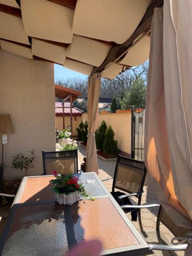a table and chairs under an umbrella on a patio at Casa Boem in Mogoşoaia