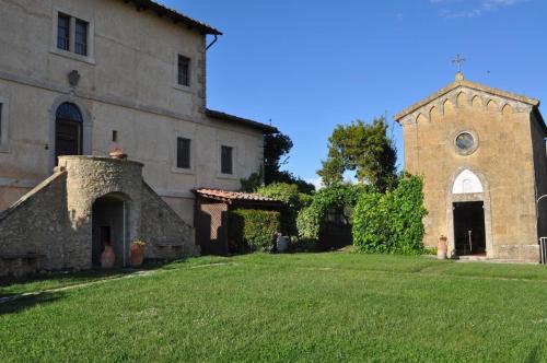 an old stone building with a small church at Tenuta Decimo - Villa Dini in San Gimignano