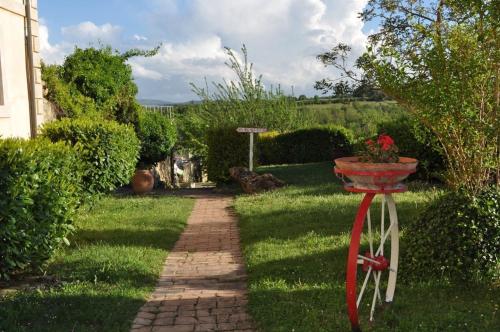 a garden with a red stand with a flower pot on it at Tenuta Decimo - Villa Dini in San Gimignano