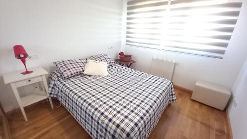 サリナスにあるAPS La Deva de Salinasの小さなベッドルーム(ベッド1台、窓付)