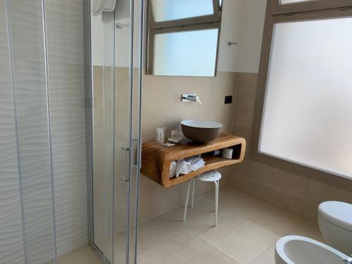 a bathroom with a sink and a glass shower at Almare' B&b in Torre Santa Sabina