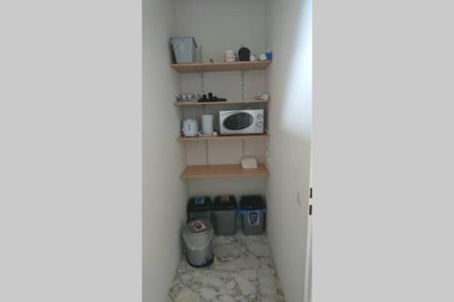 a small room with a microwave and a shelf at Apartment Karin, Eigener Eingang, 3 Schlafzimmer, Doppelcarport in Langenwang