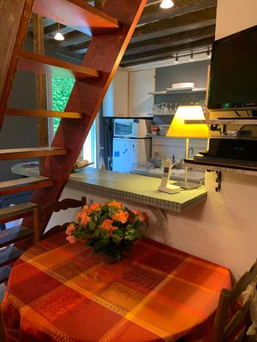 une cuisine avec une table avec un vase de fleurs dessus dans l'établissement Charming Latin Quarter Courtyard Duplex for four, à Paris