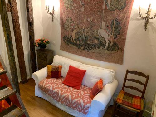 - un salon avec un canapé blanc et des oreillers rouges dans l'établissement Charming Latin Quarter Courtyard Duplex for four, à Paris
