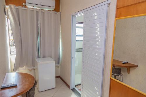 ein Bad mit einem Fenster und einem weißen Schrank in der Unterkunft Pousada Ondas do Forte in Cabo Frio