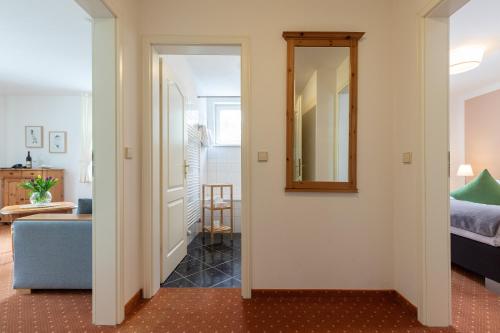 a hallway leading to a bedroom with a mirror at Seehotel Lindenhof in Lychen