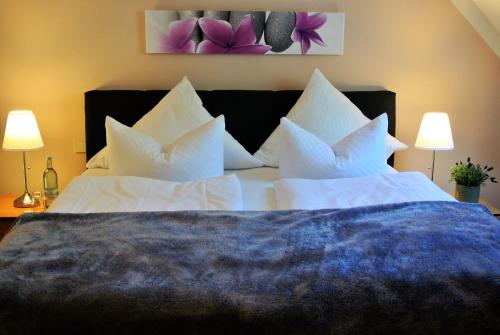 a bedroom with a large bed with white pillows at Seehotel Lindenhof in Lychen