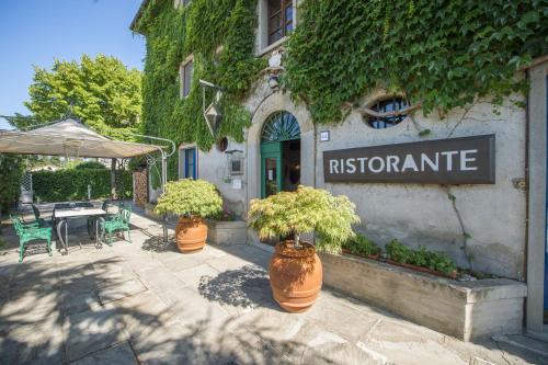 a restaurant with two potted plants in front of a building at Relais Oroscopo in Sansepolcro