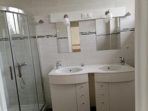 a bathroom with two sinks and a glass shower at La Petite Coccinelle in Noisy-le-Grand