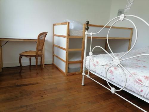 a bedroom with a bed and a desk and a chair at La Petite Coccinelle in Noisy-le-Grand