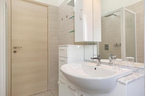 biała łazienka z umywalką i prysznicem w obiekcie Casa Nives - By Impero House w mieście Stresa