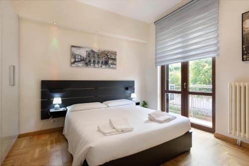 a bedroom with a large white bed and a window at Casa Nives - By Impero House in Stresa