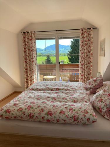 um quarto com uma cama e uma grande janela em Ferienwohnung Schmiedhansl Moos em Salzburgo