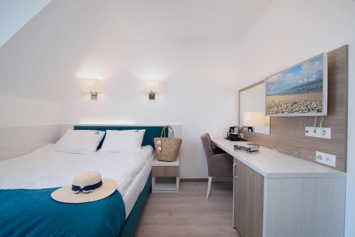 a hotel room with a bed with a hat on it at Błękitne Wzgórze - Nowoczesne Pokoje Gościnne in Władysławowo