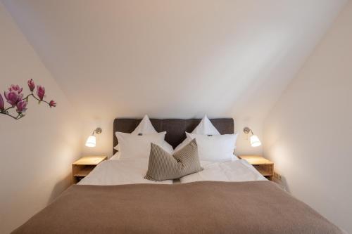 a bedroom with a bed with white sheets and pillows at Seehotel Lindenhof in Lychen