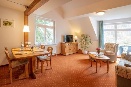 a living room with a table and a couch at Seehotel Lindenhof in Lychen