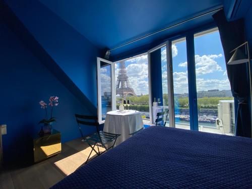 a blue bedroom with a view of the eiffel tower at Eiffel Tower romantic view in Paris