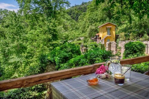 a table with a drink and flowers on a balcony at Palios Stathmos in Miléai