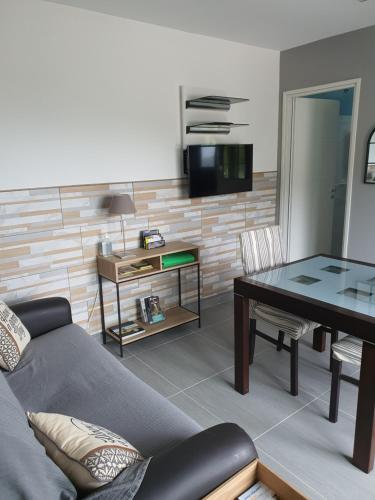 Appartement F2 avec terrasse de 35 m2 Bomorto - Porticcio في بورتيكيو: غرفة معيشة مع أريكة وطاولة