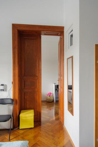 a room with a wooden door and a yellow stool at Cozy river view apartment in Karlovac