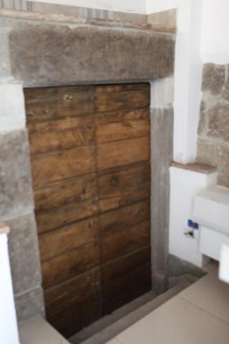 a wooden door in a bathroom with a sink at Appartamenti Dante in Vitorchiano