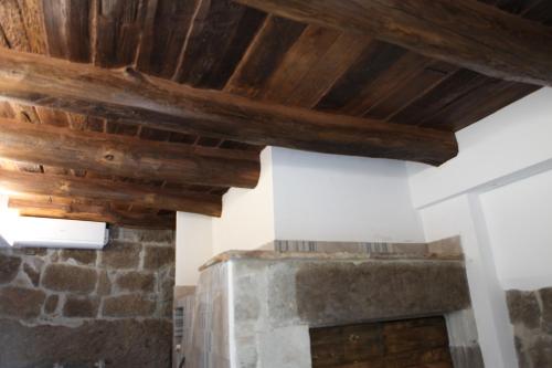 a room with wooden ceilings and a stone fireplace at Appartamenti Dante in Vitorchiano