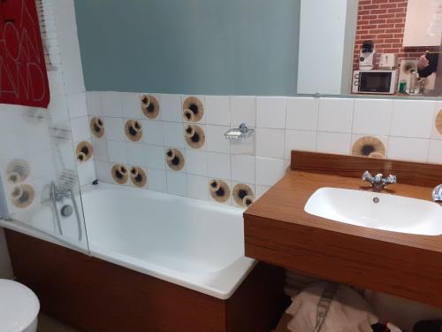 a bathroom with a sink and a tub with donuts at La Grande Moucherolle in Villard-de-Lans