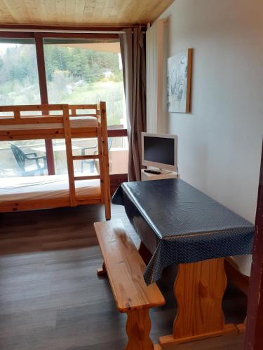 a room with a bunk bed and a desk and a tv at La Grande Moucherolle in Villard-de-Lans