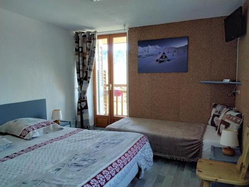 a bedroom with two beds and a window at Hôtel Le Beauséjour in Saint-François-Longchamp