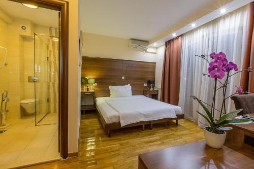 a hotel room with a bed and a bathroom at Hotel M in Podgorica