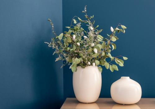 a white vase with flowers in it on a table at Mouzinho da Silveira Unique Apartments, by Oporto Collection in Porto