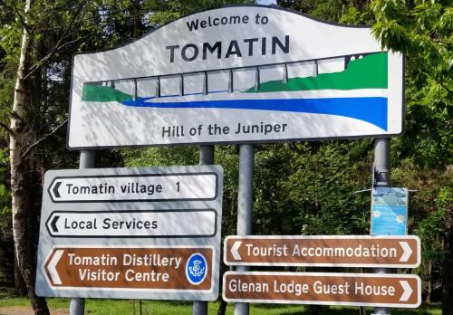 a bunch of street signs on a pole at Glenan Lodge Self Catering in Tomatin