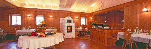 a dining room with two tables and a fireplace at Gasthof Weisses Kreuz in Naturno