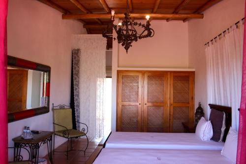 a bedroom with a large bed and a chandelier at Hotel de Charme Capela das Artes in Armação de Pêra
