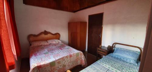 サン・ジョゼ・ド・バヘイロにあるCASA ACALANTA-Trilha das Flores-SERRA DA CANASTRAの小さなベッドルーム(ベッド2台、ドレッサー付)