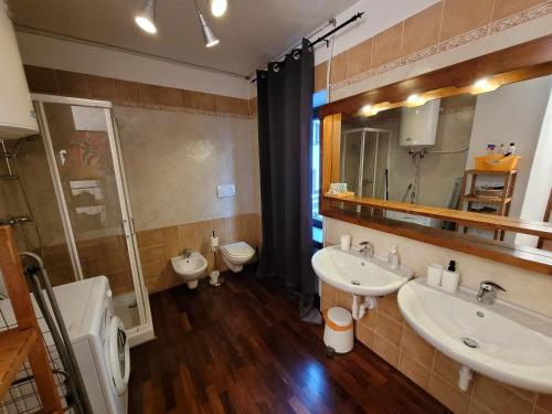 een badkamer met 2 wastafels en een toilet bij Appartamento Adalpina in Santo Stefano di Cadore