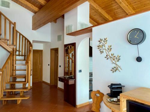 a room with a staircase and a clock on the wall at Casa Pallanch in Fai della Paganella
