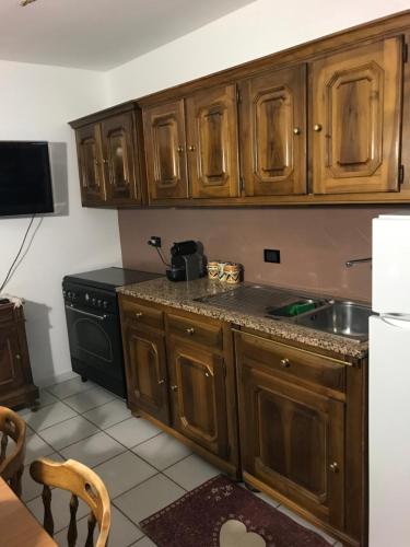 uma cozinha com armários de madeira e um lavatório em Casa 127 em Sestriere
