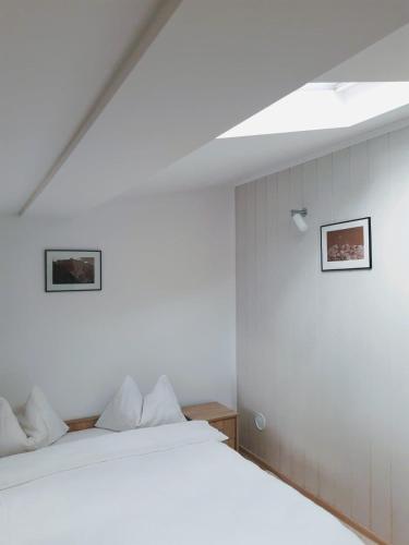 a bedroom with a white bed and a sloped ceiling at Casa cu Flori in Buşteni