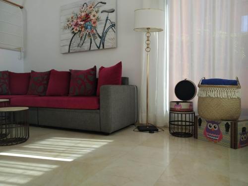 a living room with a red couch and a table at Casas de Tauro in La Playa de Tauro