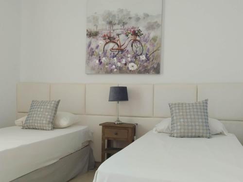 a bedroom with two beds and a painting on the wall at Casas de Tauro in La Playa de Tauro