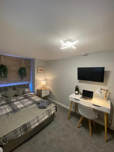 una camera da letto con un letto e una scrivania con un computer portatile di Shore Street Apartments a Inverness