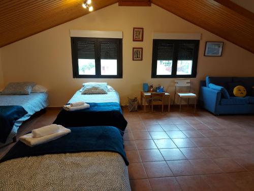 Un dormitorio con dos camas y un sofá azul. en Casa La Taratola, en Ortigosa del Monte