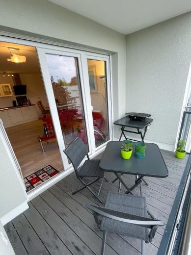 a patio with a table and chairs on a deck at Ferienwohnung König Ludwig XIV in Saarlouis