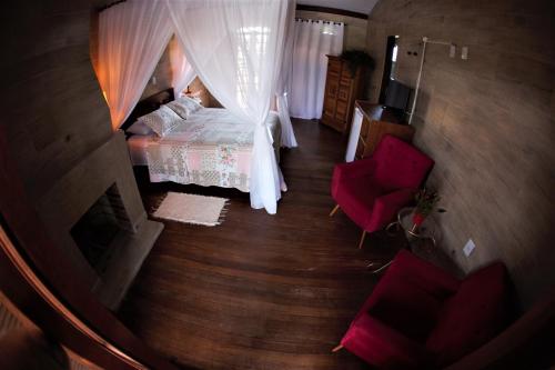 an overhead view of a bedroom with a bed and chairs at Hotel Ferrugem Eco Village in Garopaba