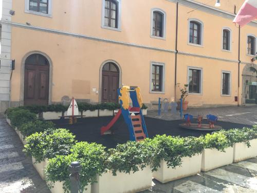 un parque infantil frente a un edificio en Intra Rooms, en Olbia