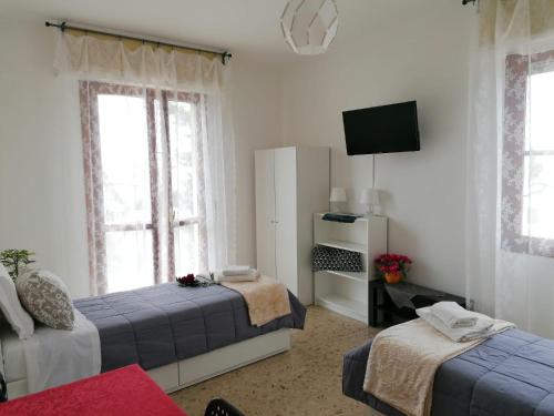 Sala de estar con 2 camas y TV en Giuseppe House, en Pisa